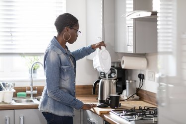 woman pouring water into kettle in kitchen using Brita water filter