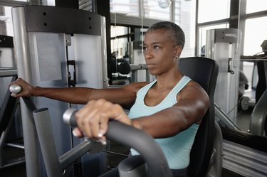 Person in health club using a gym machine.
