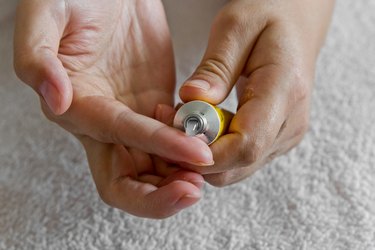 close view of a person's hands squeezing a tube of antibiotic ointment, as a stye remedy