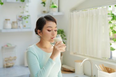 woman drinking milk from a glass in the kitchen