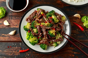 Homemade Beef and Broccoli with Rice and herbs on wooden table