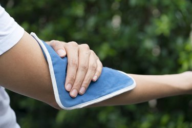 close view of a person putting a cold pack on the arm, as a natural remedy for eczema