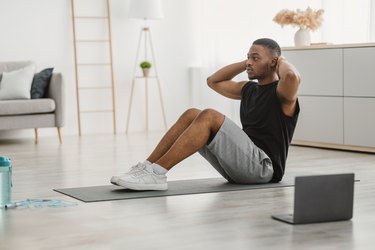 Person doing a sit-up in their living room