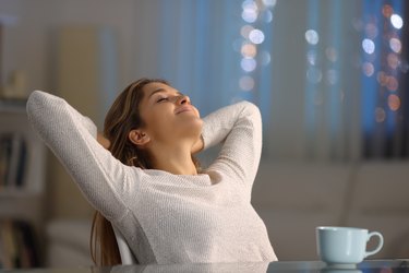 Woman resting sitting in a chair in the night at home