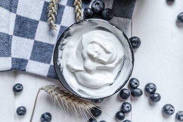 Greek yogurt in bowl on wooden table