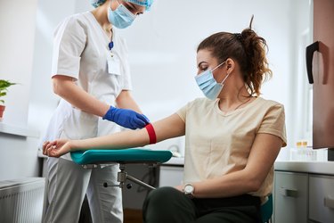 phlebotomist preparing a woman for blood draw to test white blood cell count