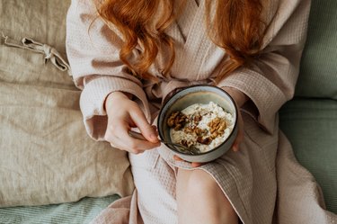 一个女人牵手一碗麦片粥,知道生病时吃早餐