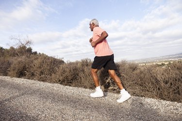 Attractive Senior Man Hill Walking With Knee Pain