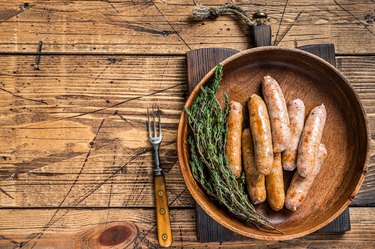 Steamed sausages in a wooden plate. wooden background. Top View. Copy space