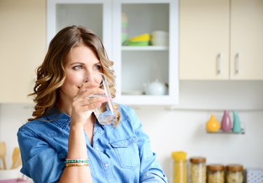 woman in the kitchen drinking a glass of water