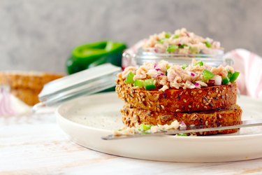 Tuna sandwich with relish and wheat bread on white plate