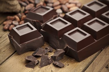 Healthy fat-rich dark chocolate bar on rustic wood table
