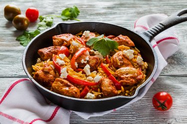 Cast-iron skillet with chicken, orzo pasta and red bell peppers