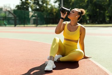 Portrait of sporty person in yellow sportswear drinking a meal-repacement shake for diabetes