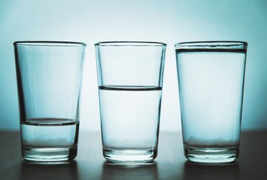 three glasses of water against a blue background