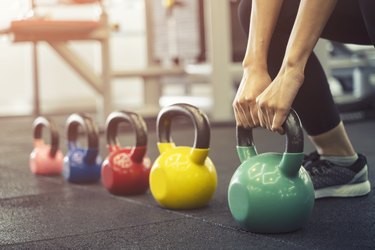 woman grabbing a heavy kettlebell during a weight-lifting workout