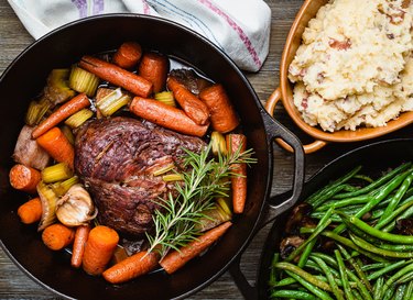 Rump roast in a Dutch oven with mashed potatoes and green beans