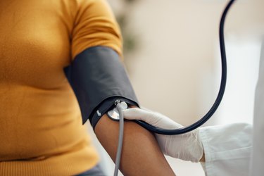 close view of a person getting their blood pressure taken by a doctor