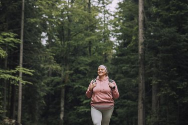 Woman in a pink sweatshirt hiking in the woods