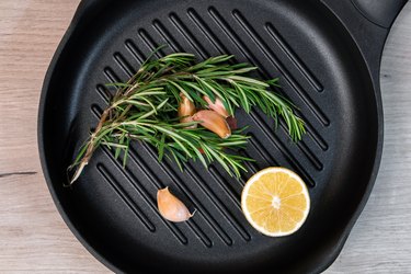 Black frying pan with rosemary, lemon and garlic