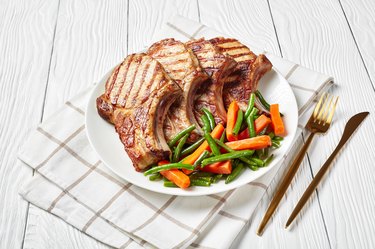 Grilled pork loin cutlets served with green bean and carrots salad