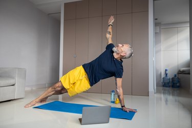 Healthy man carrying out a side plank during workout