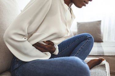 Woman holds stomach because of gas pain