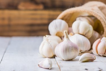 a bunch of garlic bulbs on a wooden table