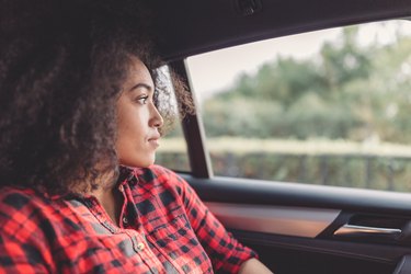 Young woman in a car looking into the distance, as a natural remedy for nausea
