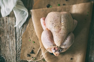 Uncooked Chicken on Butcher Paper on Wooden Countertop