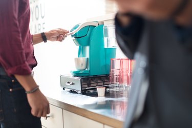 Cropped shot of businessman using coffee machine