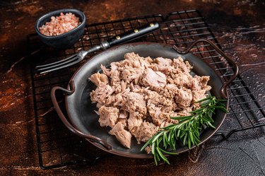 Canned tuna on a black plate, as an example of a low-calorie high-protein food