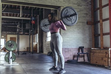 Person training with barbells at the gym.