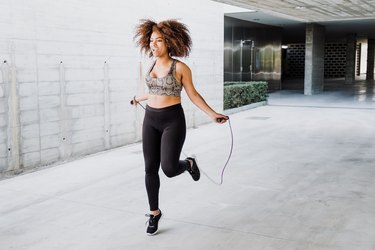 Curvy African American Woman Skipping Rope In Urban Area