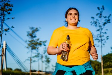 年轻女子在黄色衬衫外面做walk jog运动