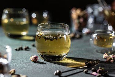 Transparent cup of green tea. Dark photography.