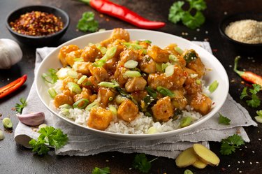 Crispy tofu with rice, green onion and rice in white bowl