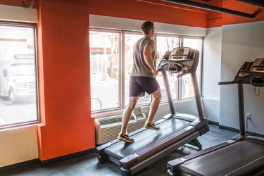 an adult runs on a treadmill at an incline to calculate elevation gain