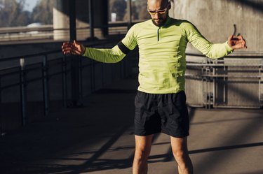 Young Bald Athlete Doing Jumping Jacks on the Street