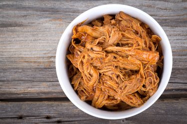 bbq pulled pork bowl over a wooden plank table
