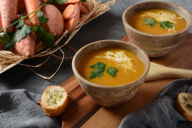 Sweet potato and carrot soup on rustic table to reap sweet potato benefits for longevity
