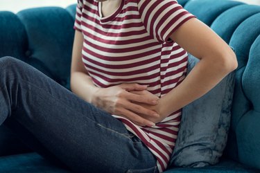 Unhealthy Asian woman hands touching her belly, Looking like stomach pain