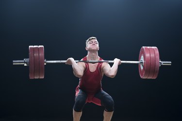 Male weightlifter performing clean and jerk lift