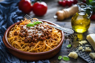 Spaghetti with Bolognese sauce shot on rustic wooden table
