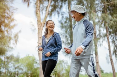 two people walking in a park for exercise to help treat knee arthritis pain