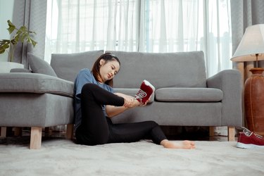 A person takes off shoes on swollen feet after running