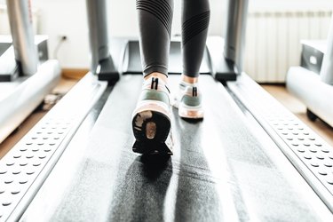 close up of a woman's sneakers running on treadmill