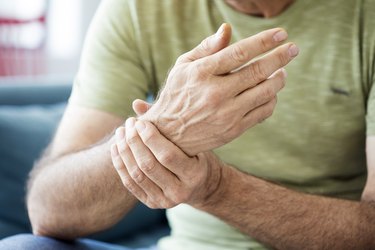 Older man holding his wrist after waking up with numb hands