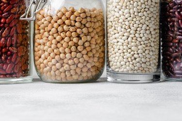 Raw cereals or beans in glass jars close up. Vegan and vegetarian food.