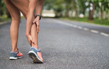 woman holding her leg from a cramp while running-- a common need for increasing potassium quickly.